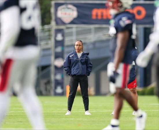 Maya Ana Callender on the field with the New Engl和 Patriots.